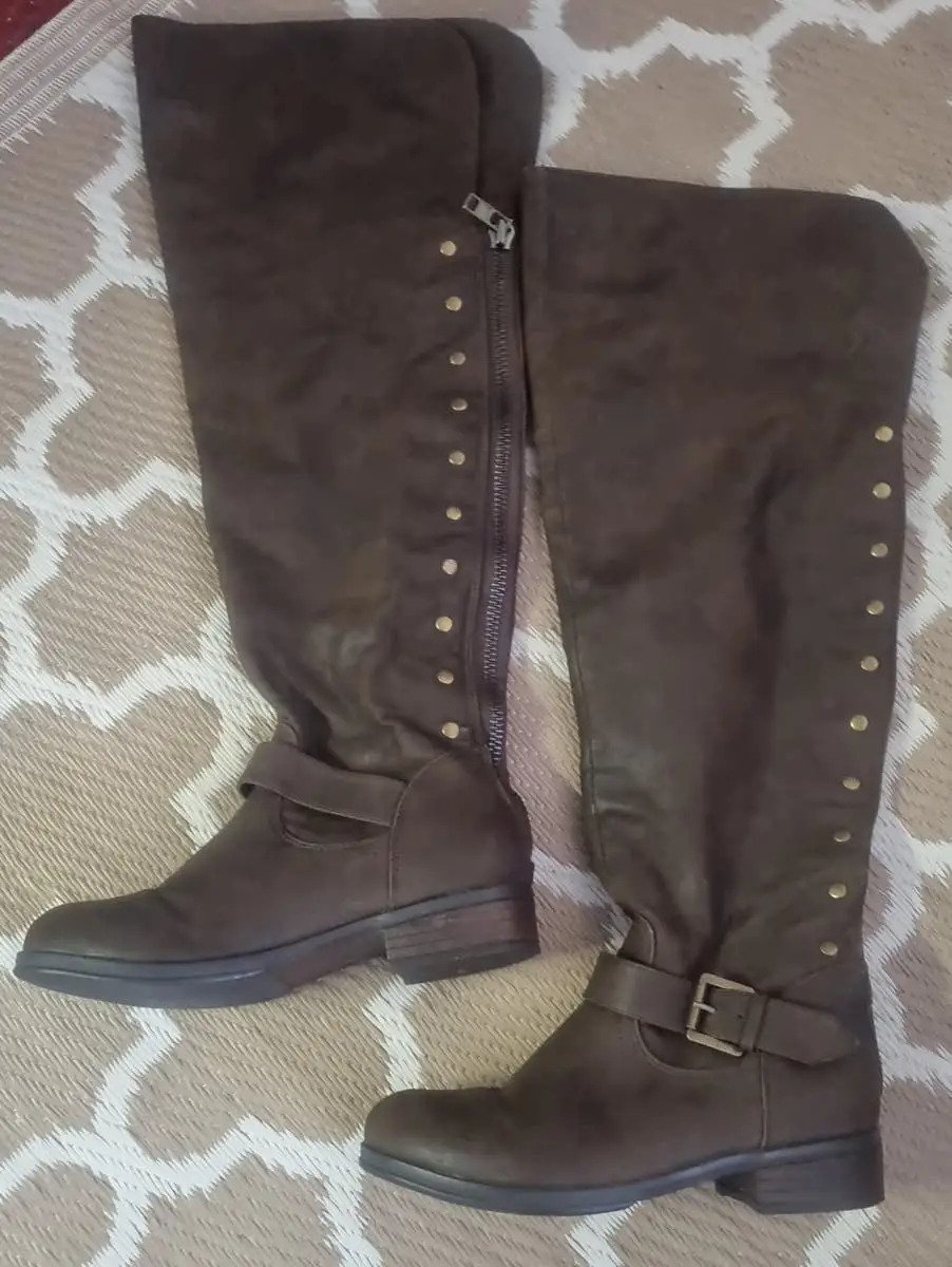 Knee-high riding boots in a dark brown faux suede/micro-suede finish. Features stud embellishments,